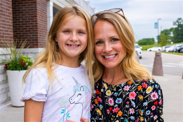 mom and girl smiling with arms around each other